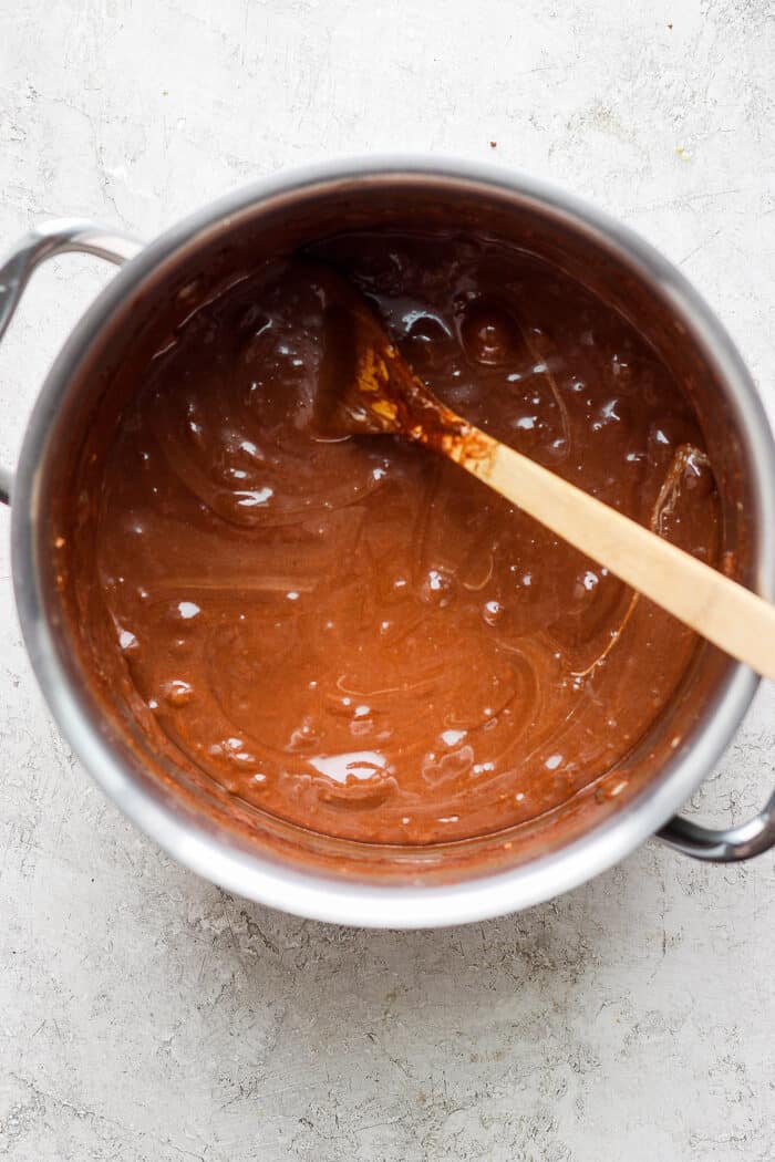 Mini marshmallows, chocolate chips, butter, and peanut butter are shown melting in a pot.