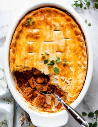 A spoon digs into a beef pot pie.