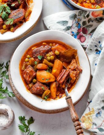 Bowls of Mulligan stew are shown on a flowered tablecloth.