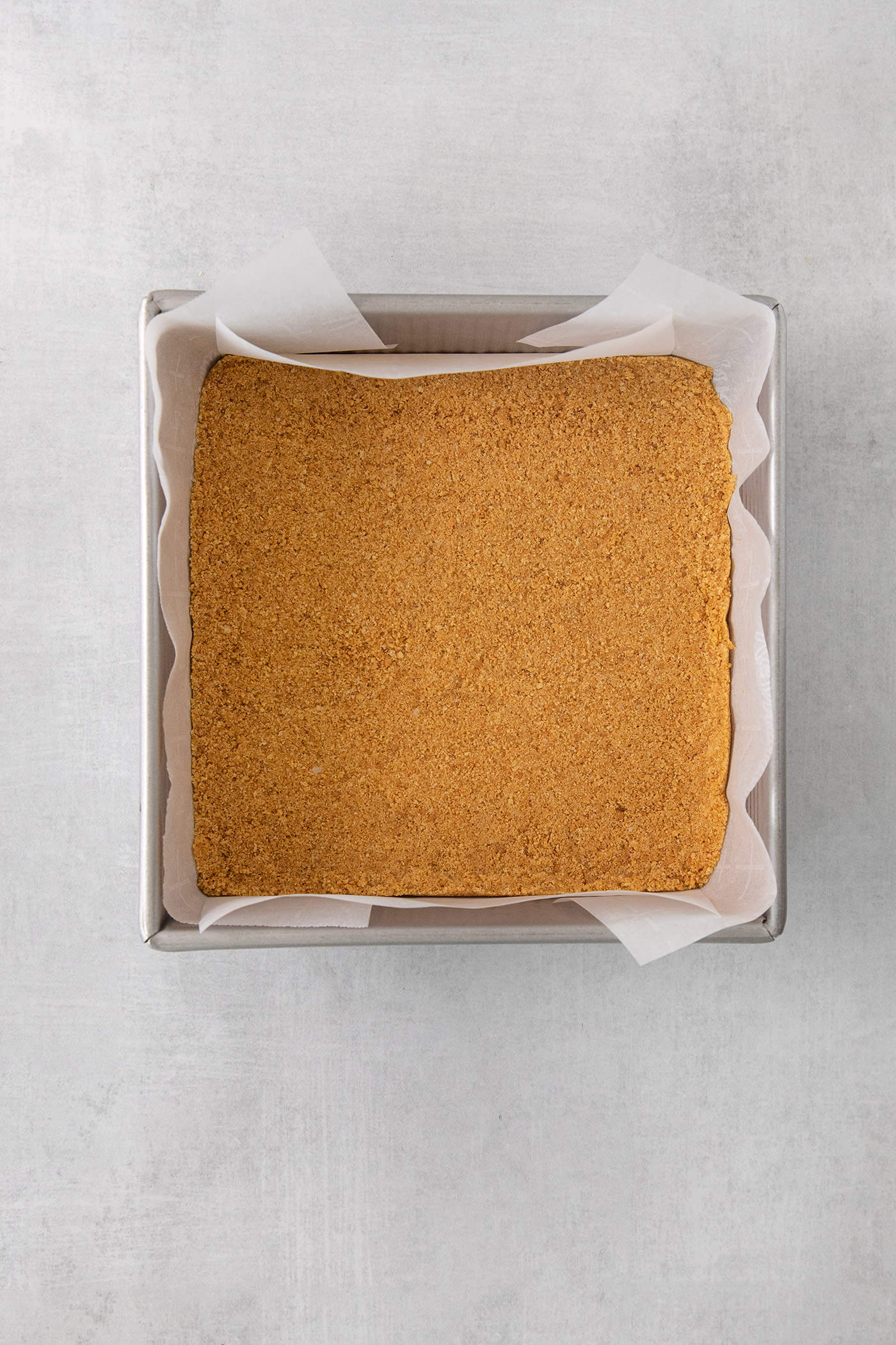 A crust is shown in a square baking pan.