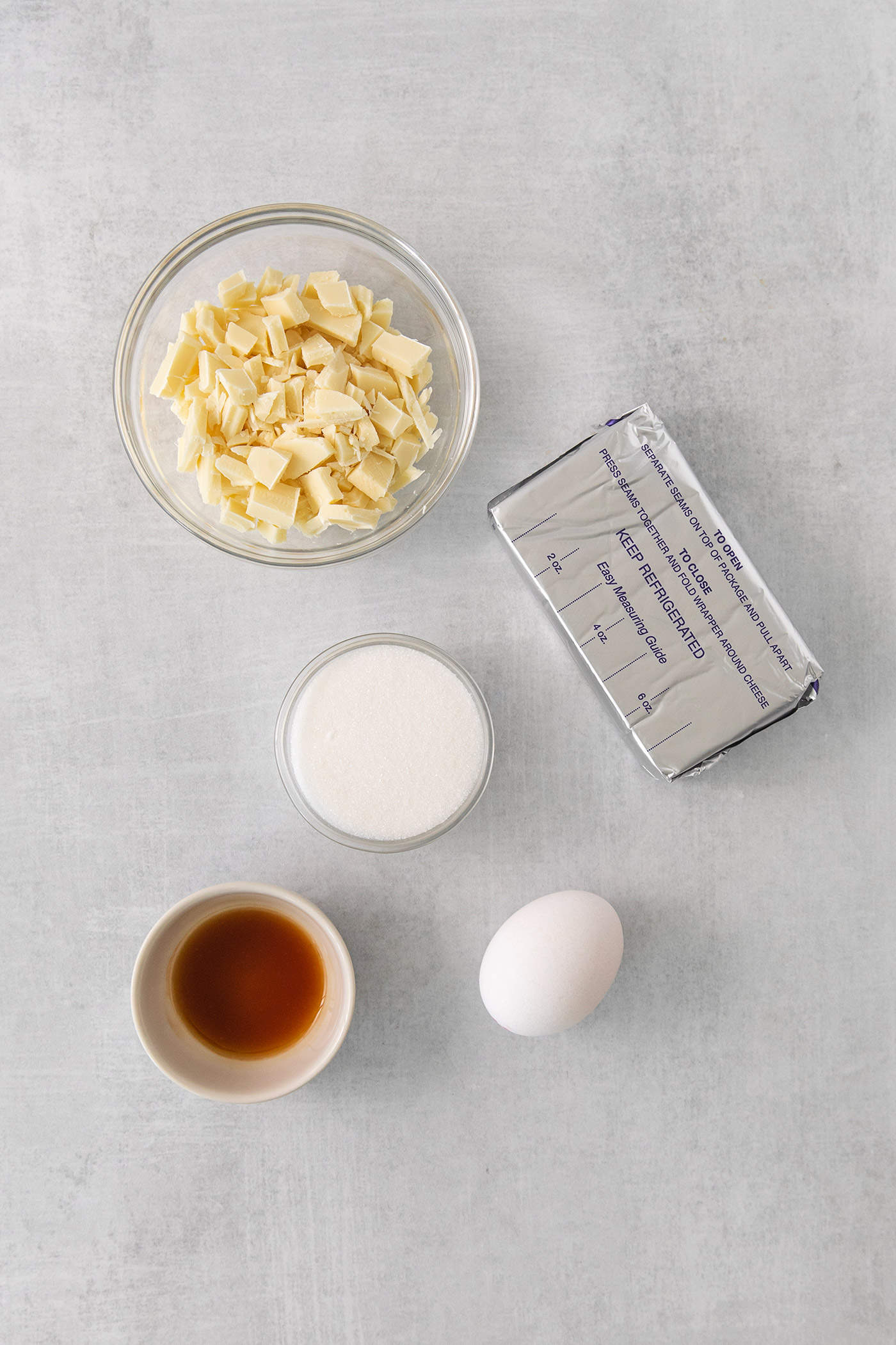 Ingredients for pumpkin cheesecake bars filling are shown on a white background: cream cheese, egg, milk, butter.