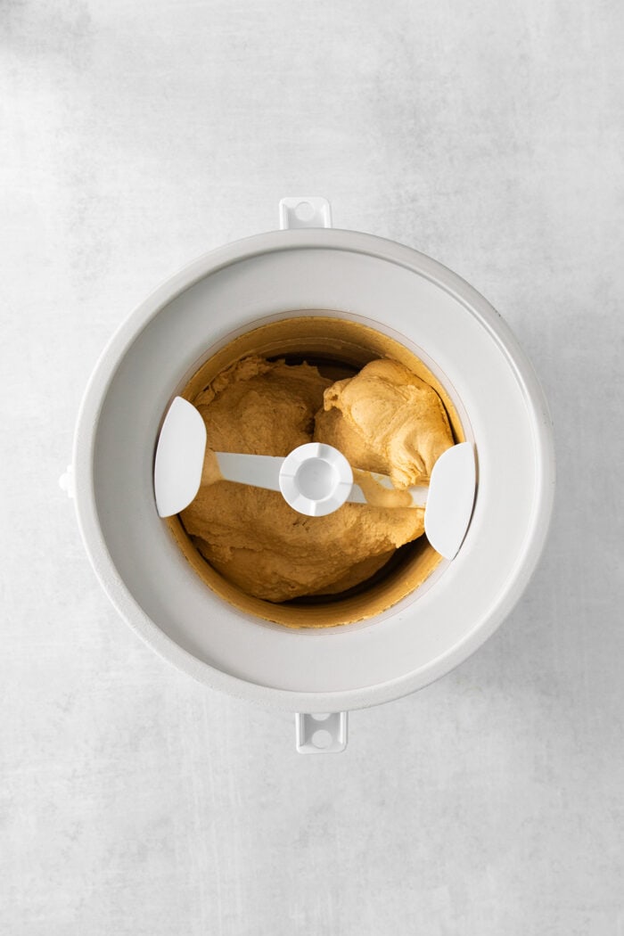 Pumpkin ice cream churns in an ice cream maker.