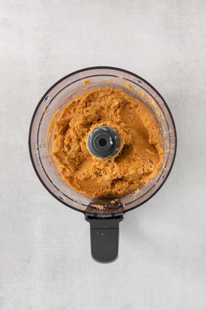 A food processor full of pumpkin pie truffle mix.