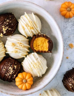 A white bowl of pumpkin pie truffles is shown on a white background.