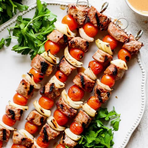 Honey mustard beef kabobs are shown together on a white plate.