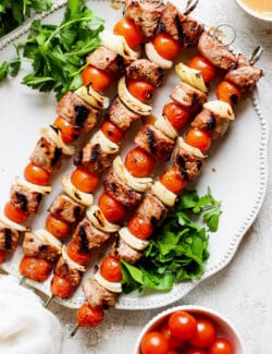 Honey mustard beef kabobs are shown together on a white plate.