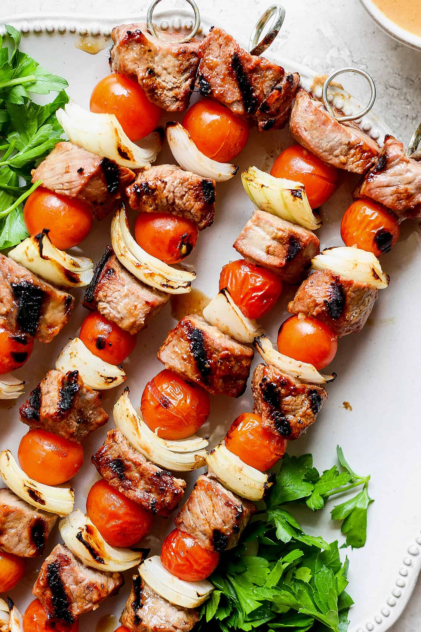 Honey mustard beef kabobs are shown together on a white plate.