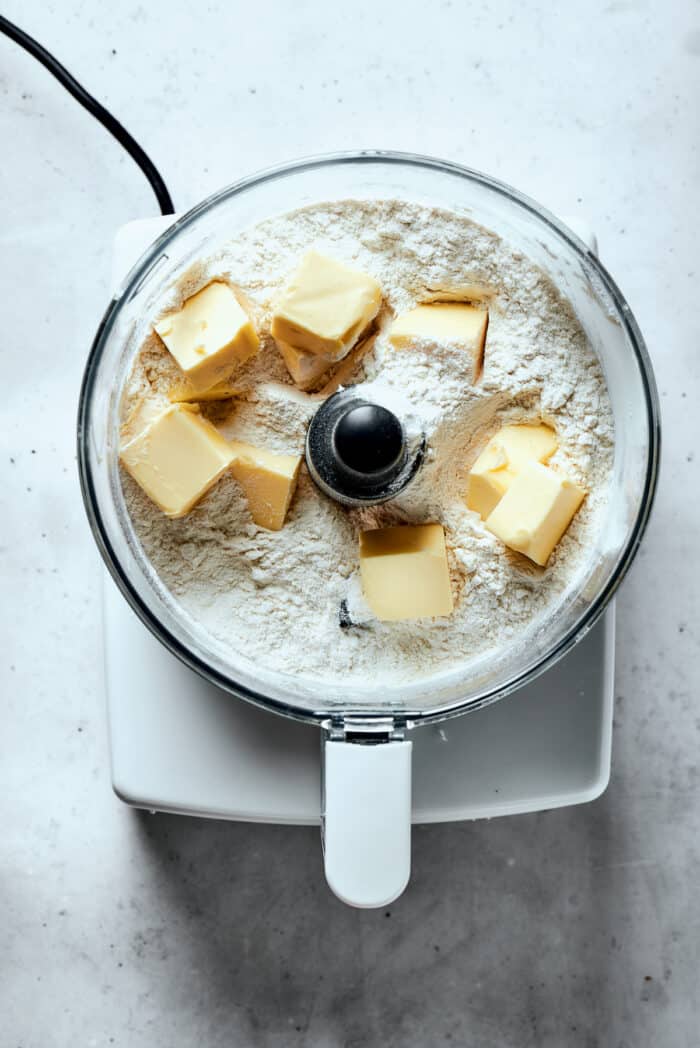 Butter is added to a flour mix in a food processor.