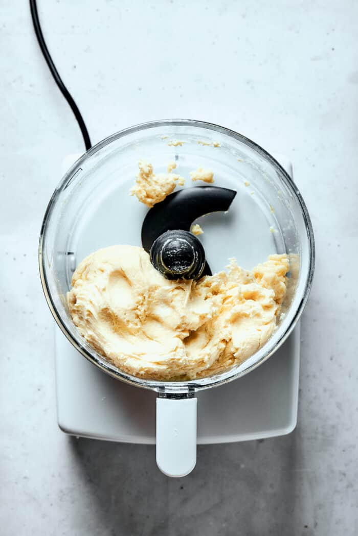 A top down shot of pastry dough in a food processor.