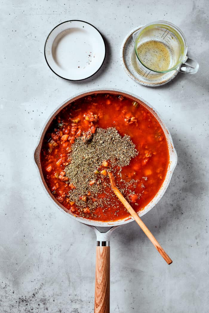 Herbs are shown on top of a pot of pasta fazool.