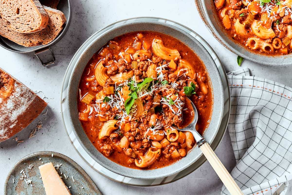 A top down shot of bowls of pasta fazool on a table.