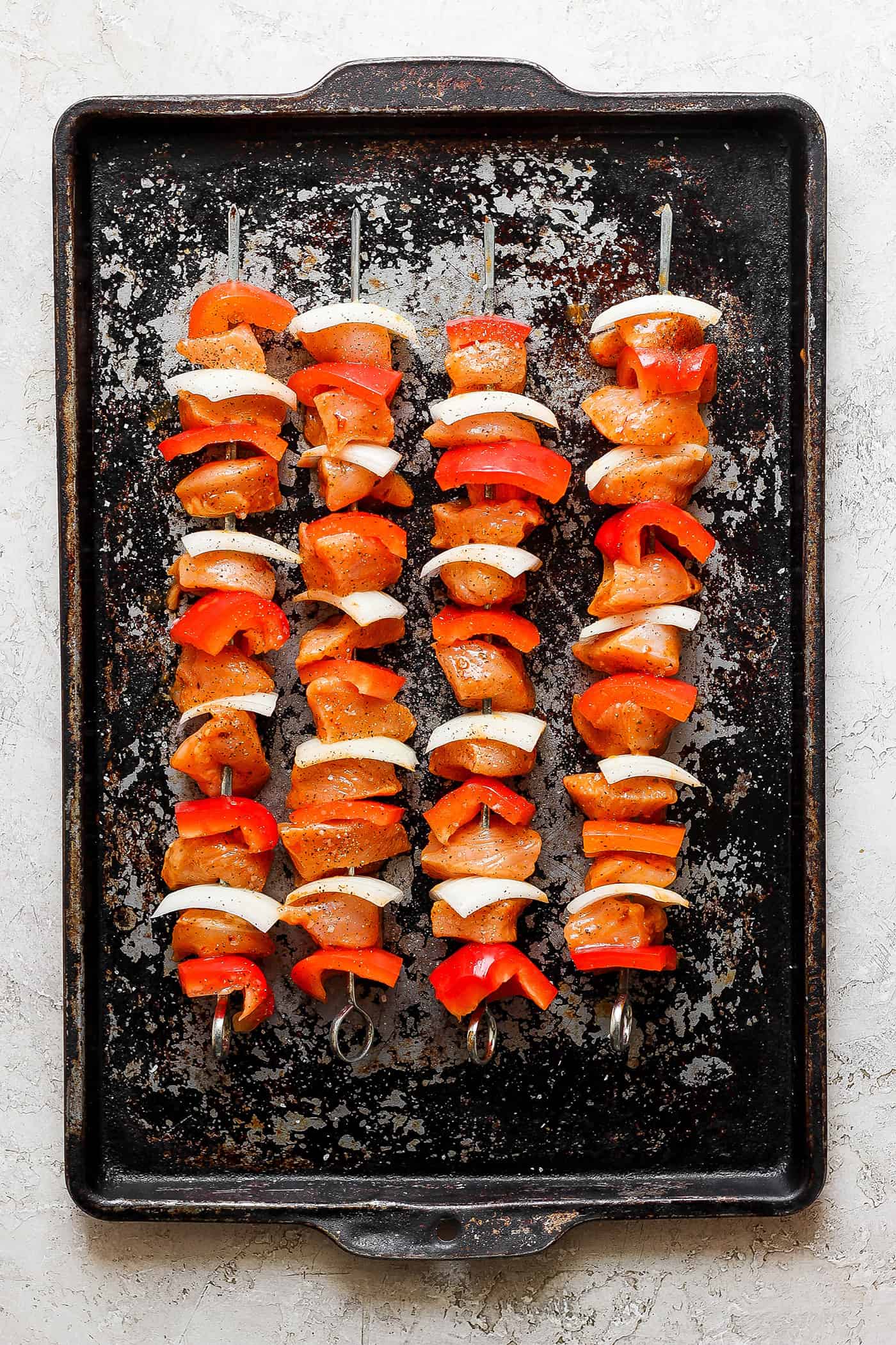 Chipotle honey chicken skewers are shown cooking on the grill.