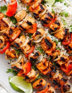 A close up shot of chipotle honey chicken kabobs with rice.