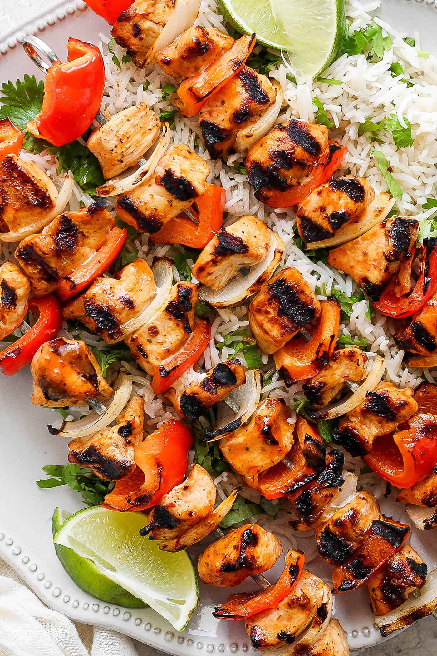 A close up shot of chipotle honey chicken kabobs with rice.