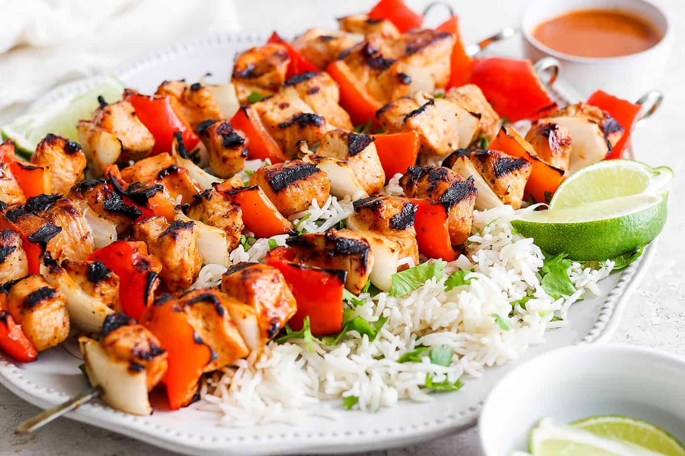 A platter of chipotle honey chicken kabobs is shown with cilantro rice.