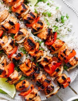 A close up shot of chipotle honey chicken kabobs with rice.