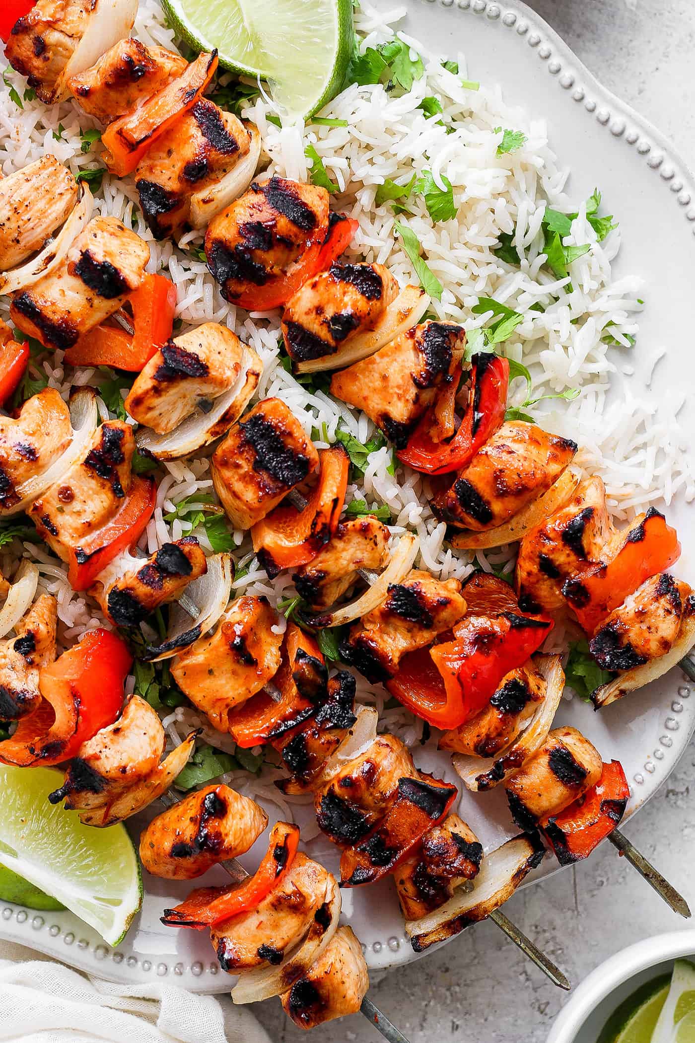 A close up shot of chipotle honey chicken kabobs with rice.
