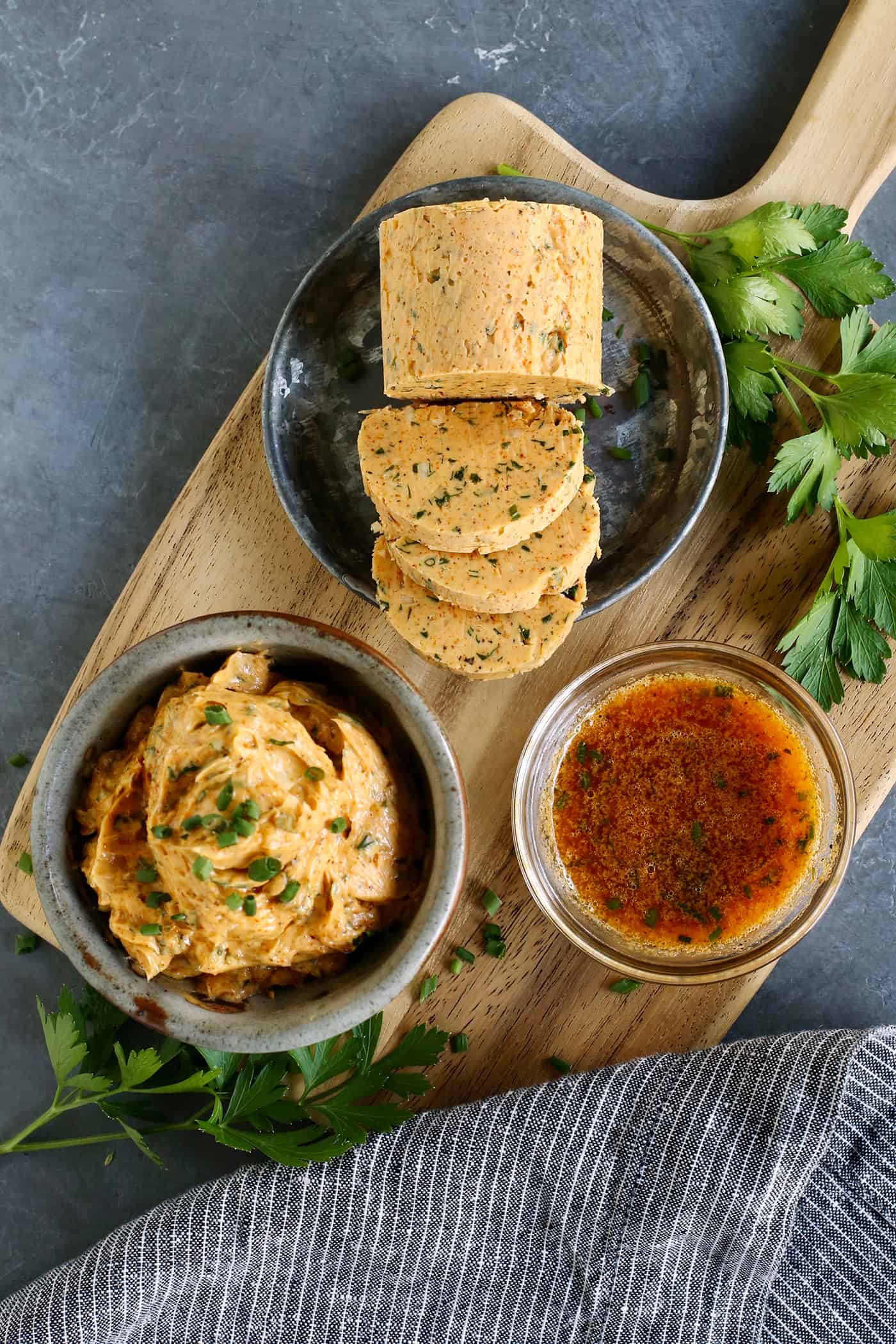 Cowboy butter on a wood board: in a bowl, formed into a log, and melted