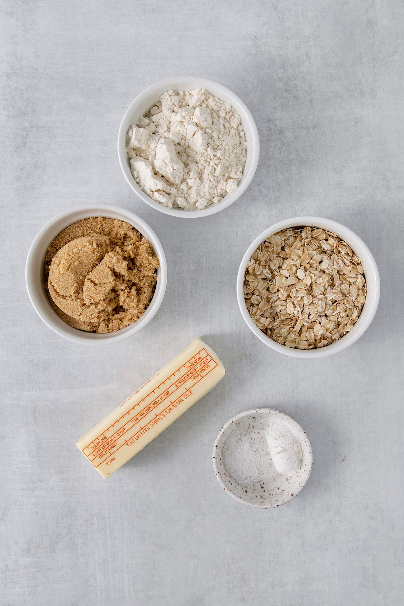 The topping ingredients for cranberry apple crisp are shown: brown sugar, oats, butter, flour.