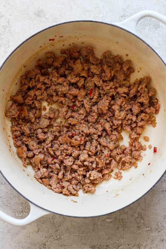 Meat is shown browning in a pot.