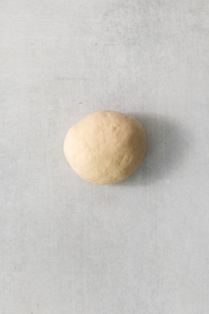 A dough round shown in a ball to make a rhodes roll.