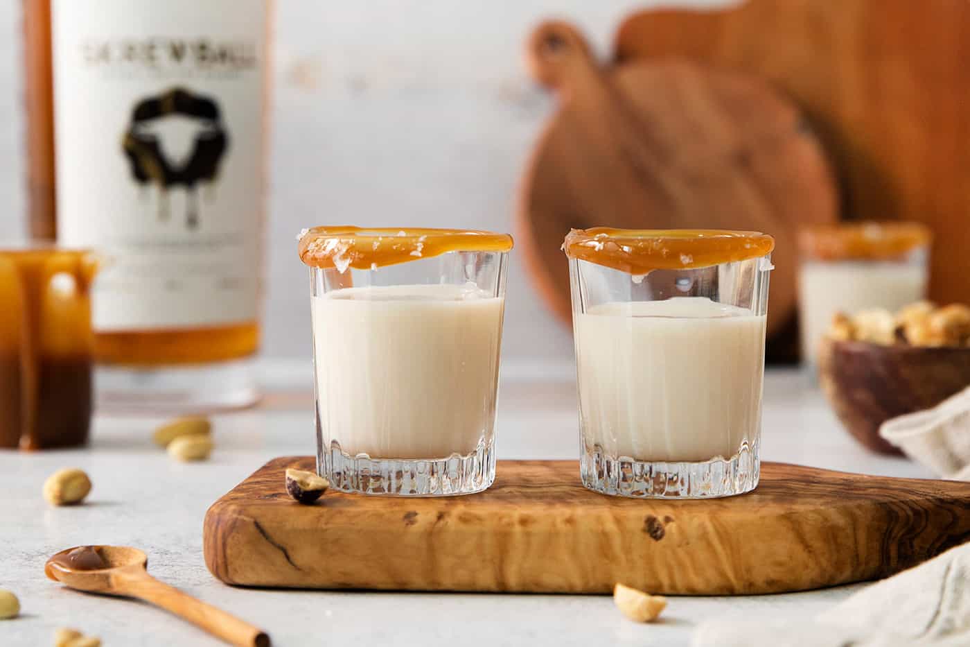 Two salted nut roll shot drinks are shown on a cutting board.