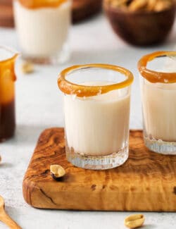 Two salted nut roll shot drinks are shown on a cutting board.