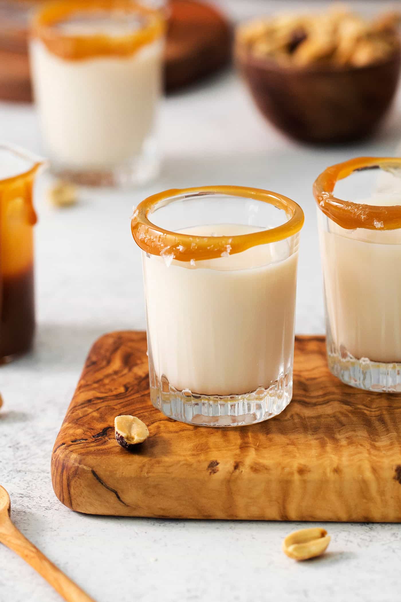 Two salted nut roll shot drinks are shown on a cutting board.