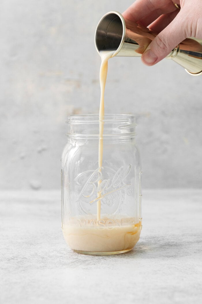 Rumchata is poured into a mason jar.