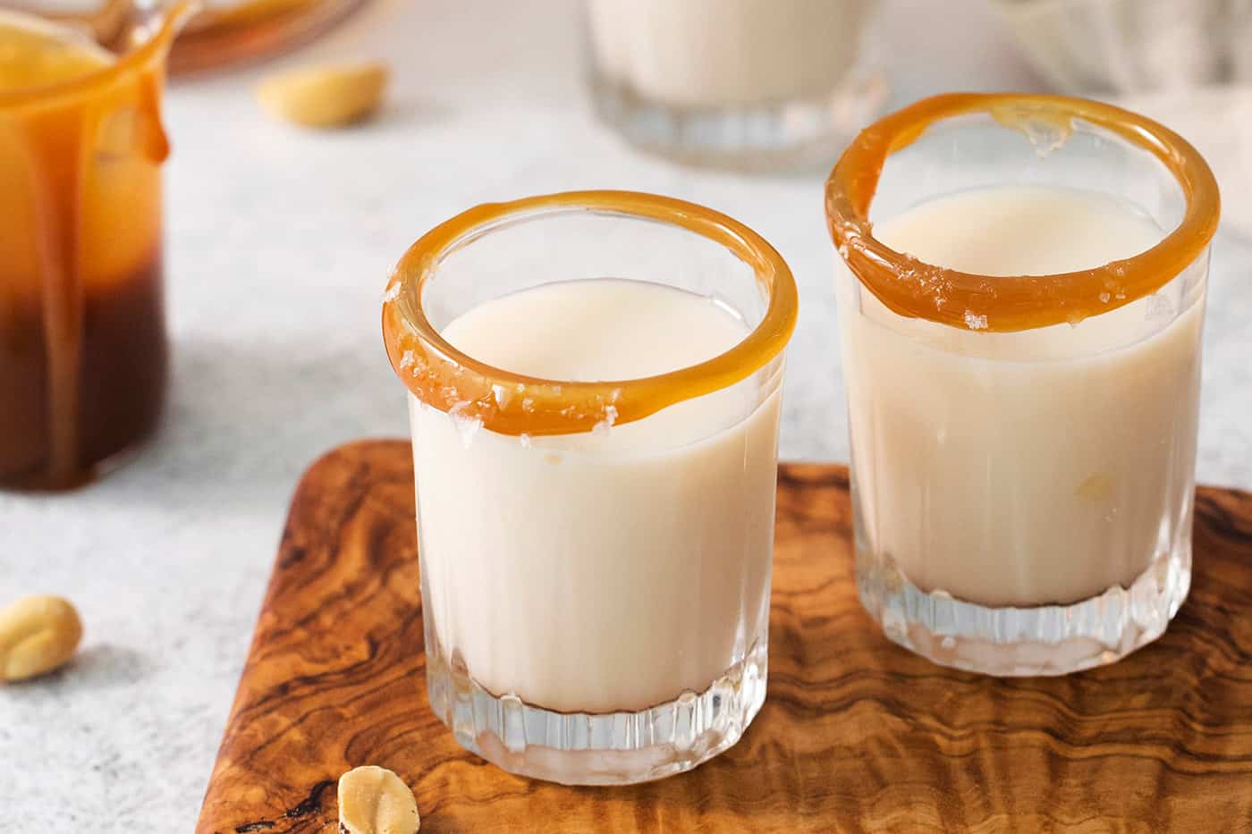 Two salted nut roll shot drinks are shown on a cutting board.