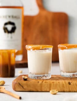 Two salted nut roll shot drinks are shown on a cutting board.