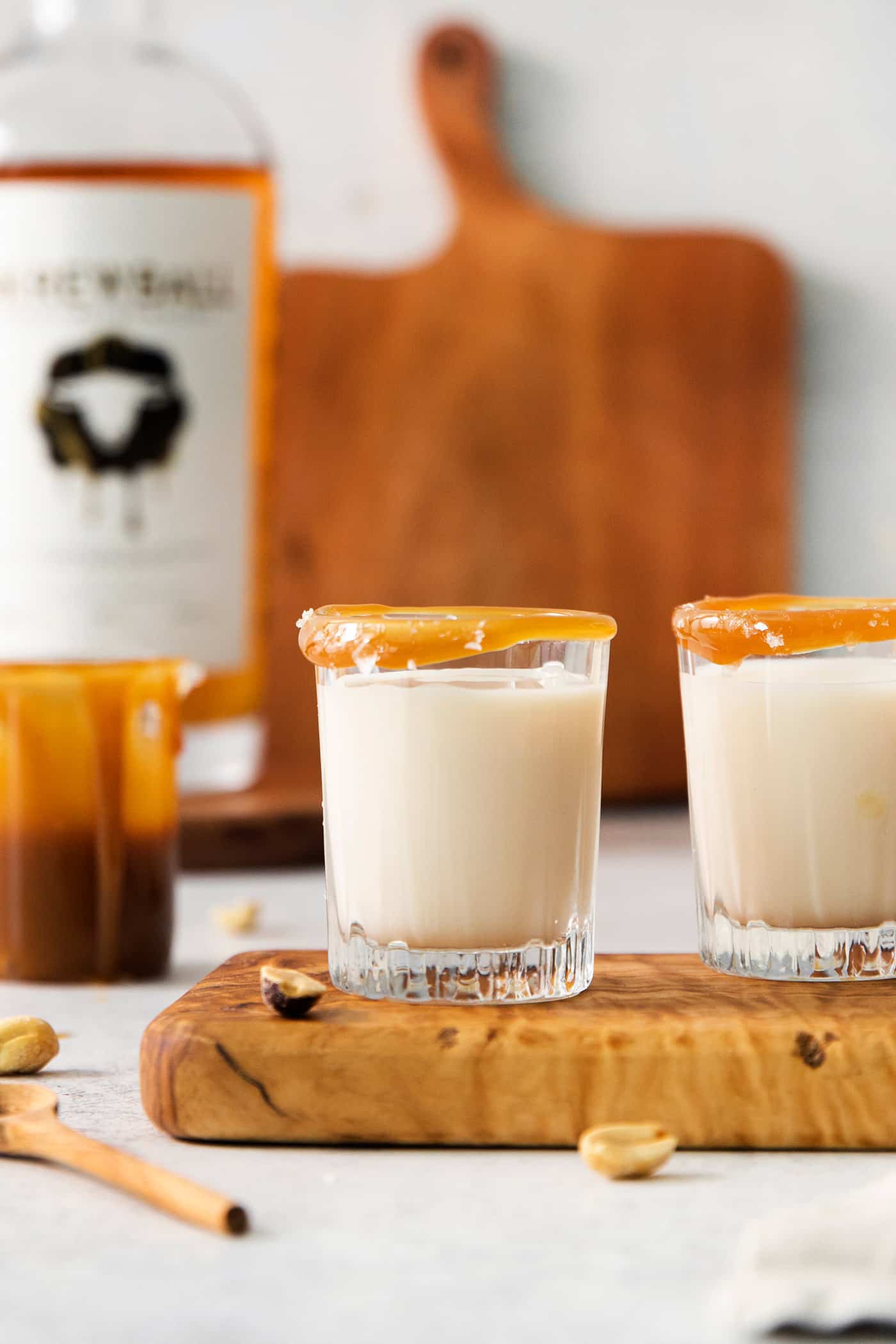 Two salted nut roll shot drinks are shown on a cutting board.