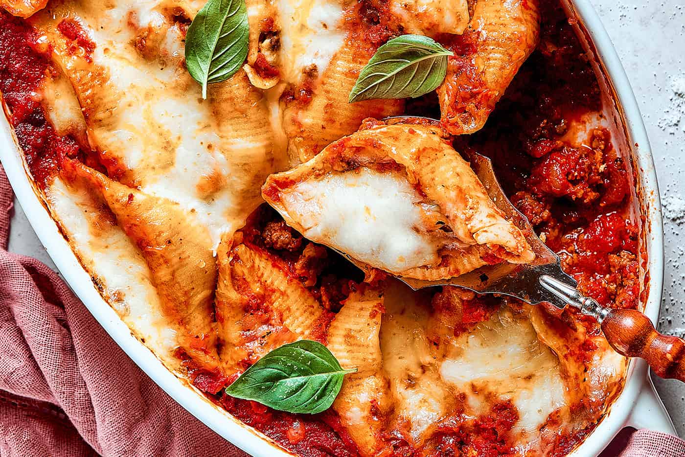 pasta shells stuffed with meat and cheese in a baking dish