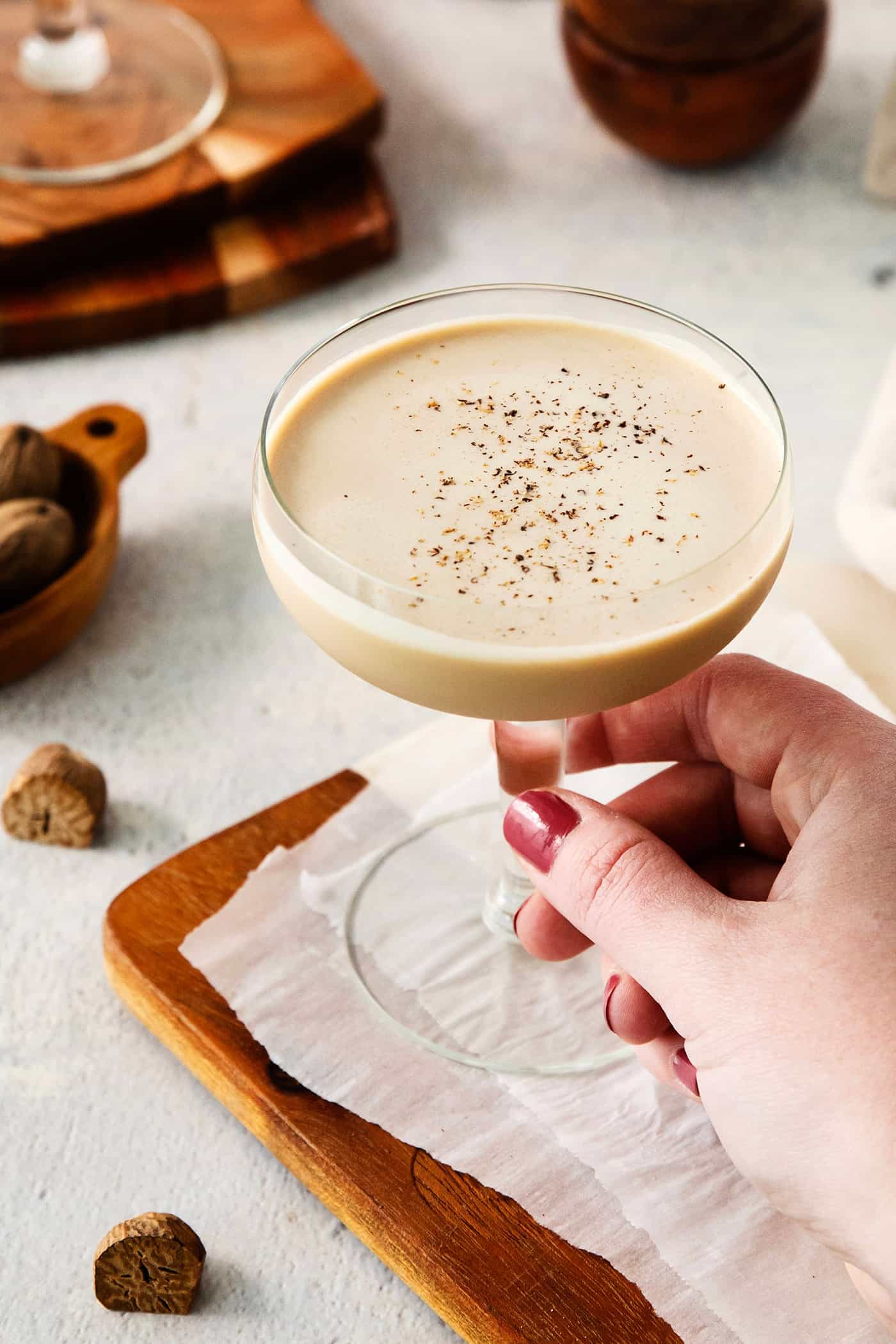 A hand holds a glass of Brandy Alexander.