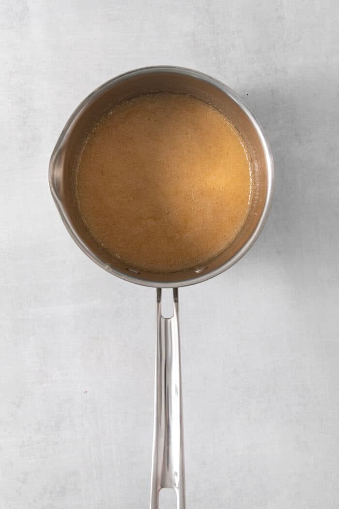 A metal pot holds caramel sauce.