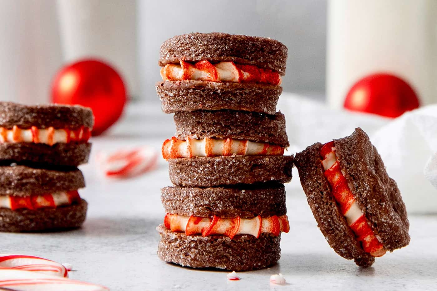 A stack of three chocolate wafer cookies with peppermint filling and more scattered nearby.