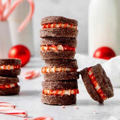 A stack of three chocolate wafer cookies with peppermint filling and more scattered nearby.
