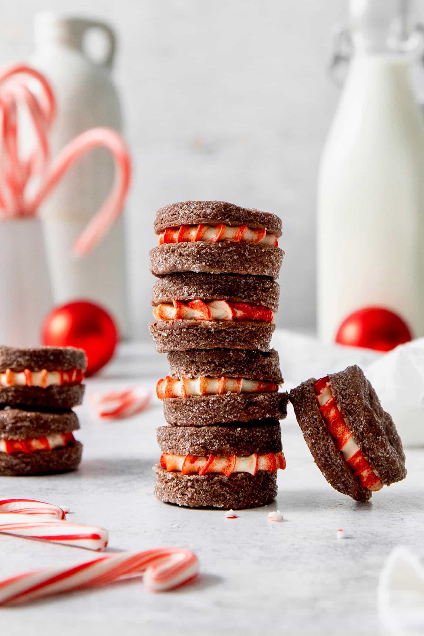 A stack of three chocolate wafer cookies with peppermint filling and more scattered nearby.