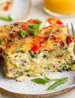 A plate of cottage cheese egg bake with a glass of orange juice.