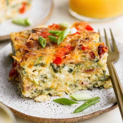 A plate of cottage cheese egg bake with a glass of orange juice.