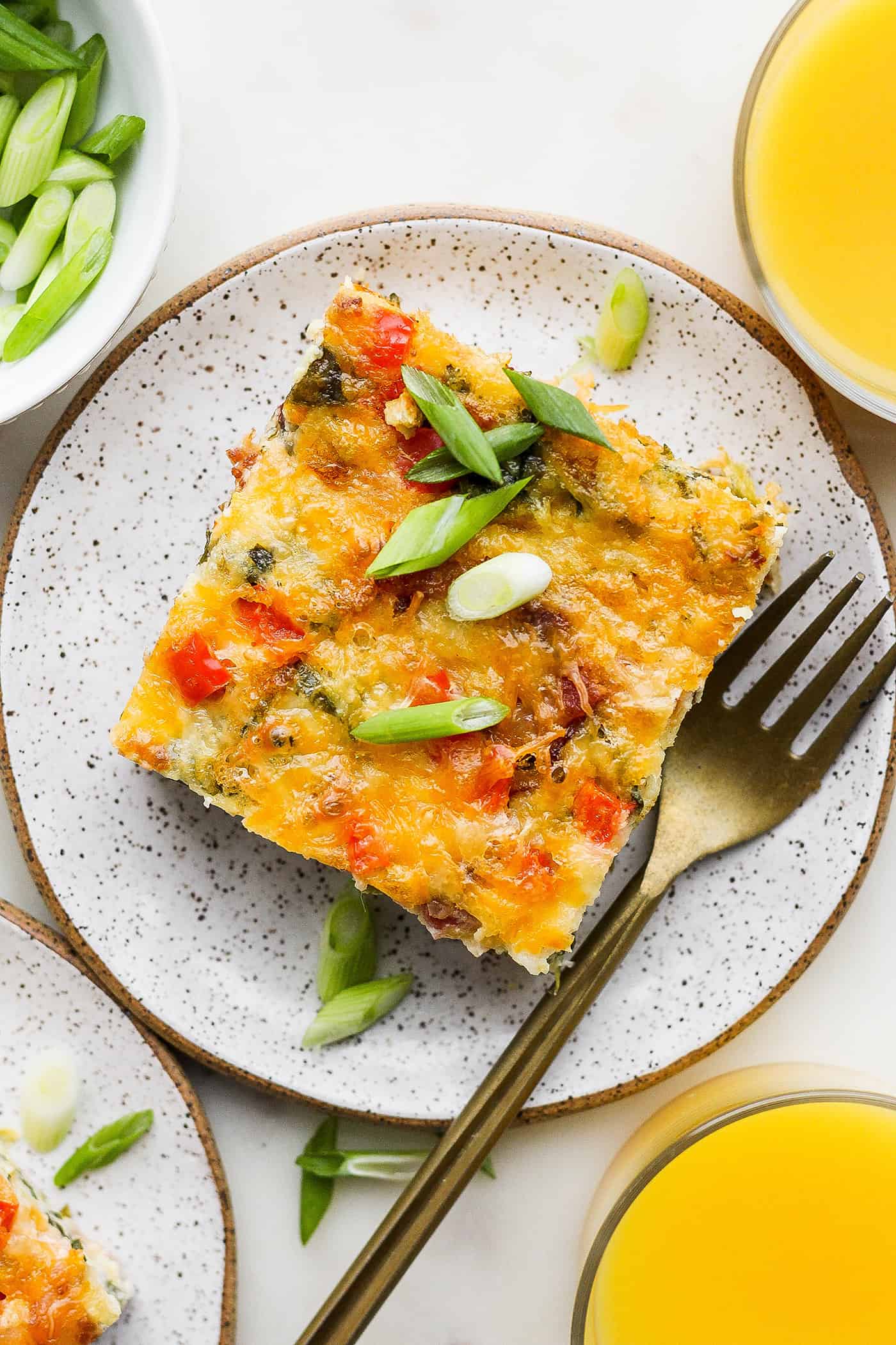 A top down shot of a piece of cottage cheese egg bake on a plate with a fork.