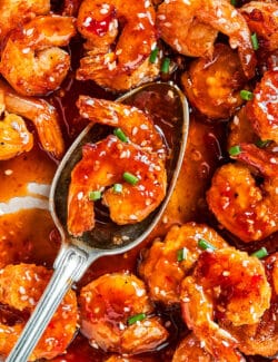 a serving spoon with firecracker shrimp on it