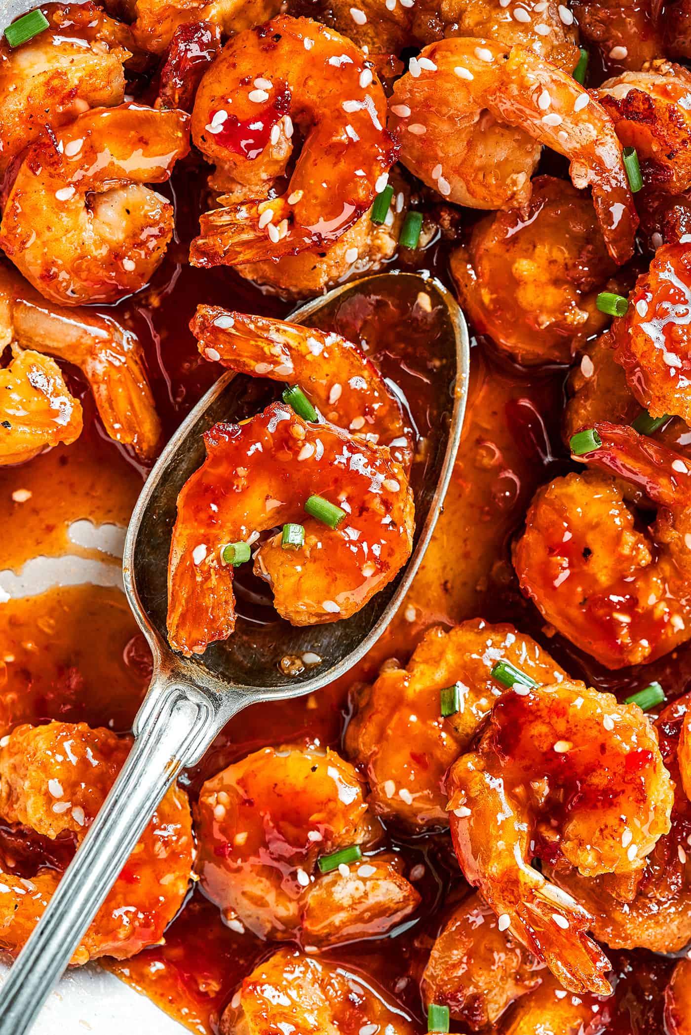 a serving spoon with firecracker shrimp on it