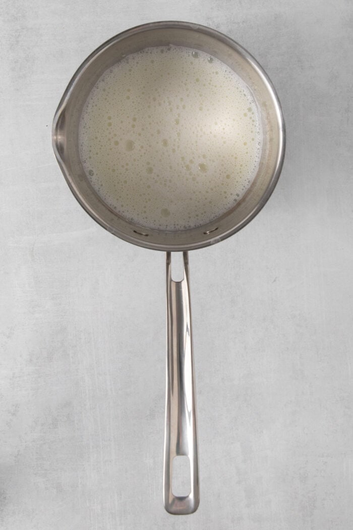 A metal pans holds warm milk.