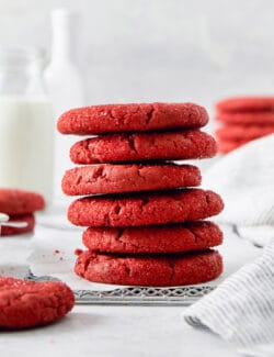 A stack of red velvet cookies with more cookies in the background.