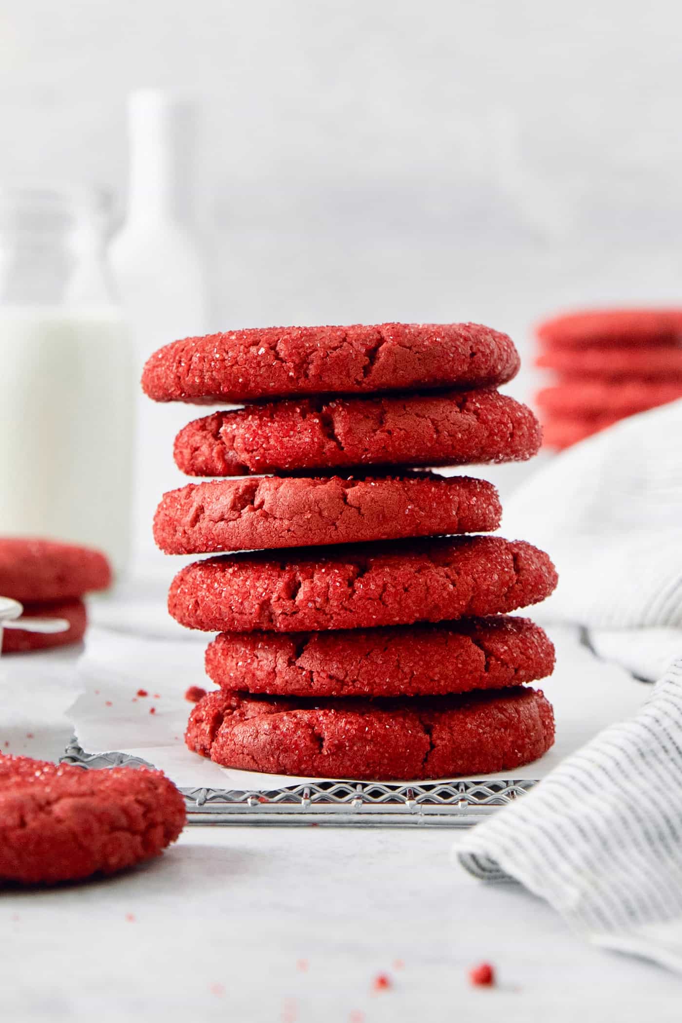 A stack of red velvet cookies with more cookies in the background.