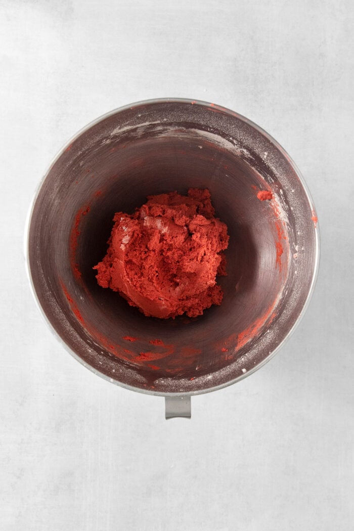 A top down shot of a metal bowl of red velvet cookie dough.