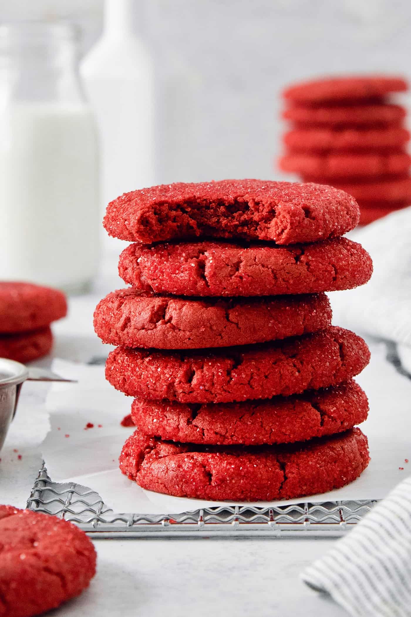 A stack of red velvet cookies, with the top cookie having a bite taken out.