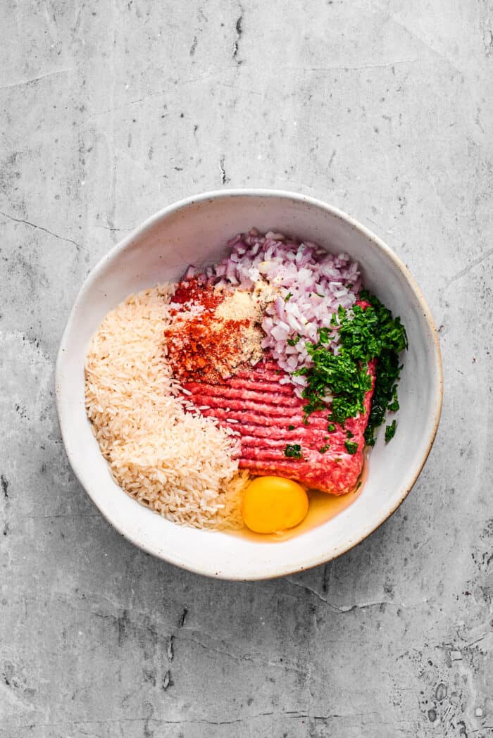 Eggs, rice, seasonings, garlic, and parsley, are added to ground beef.