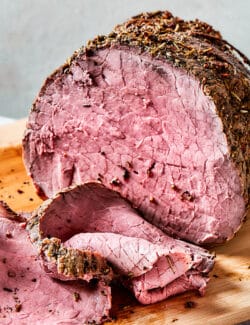 roast beef on a wood cutting boards, with some of it sliced